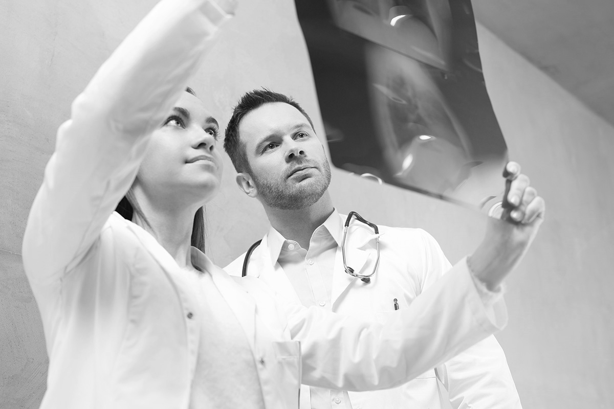 Das Bild zeigt zwei Ärzte, die sich ein Röntgenbild anschauen.