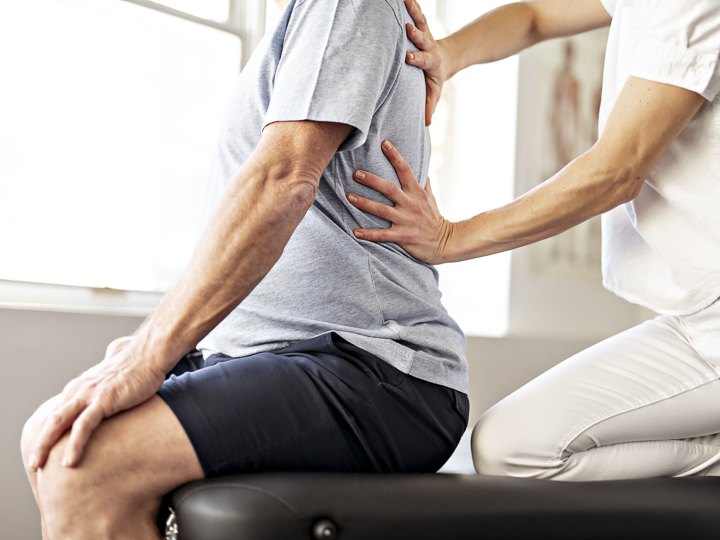 Das Bild zeigt zwei Personen bei einer physiotherapeutischen Übung.
